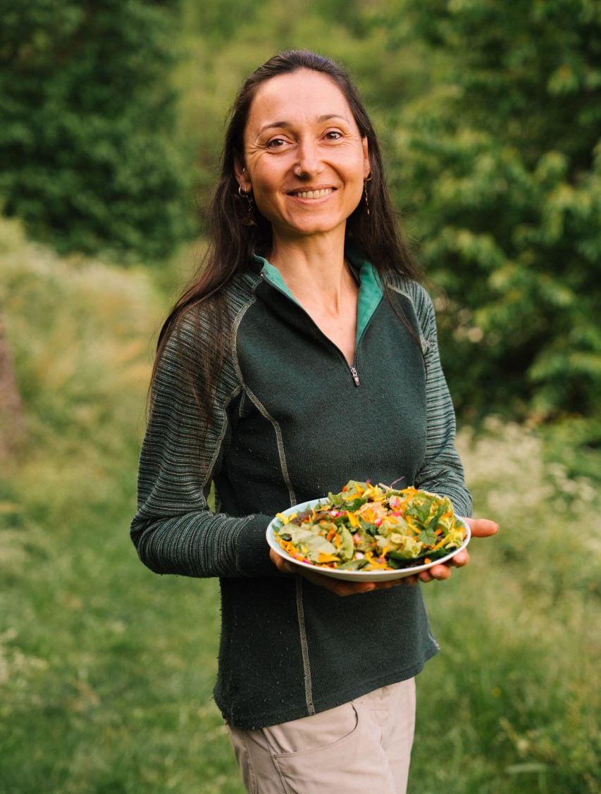 Véronique, une assiette à la main, dans la nature